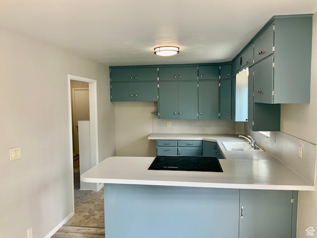165 W 500 N, Richfield, UT 84701 - kitchen with a sink, a peninsula, black electric cooktop, light countertops, and baseboards