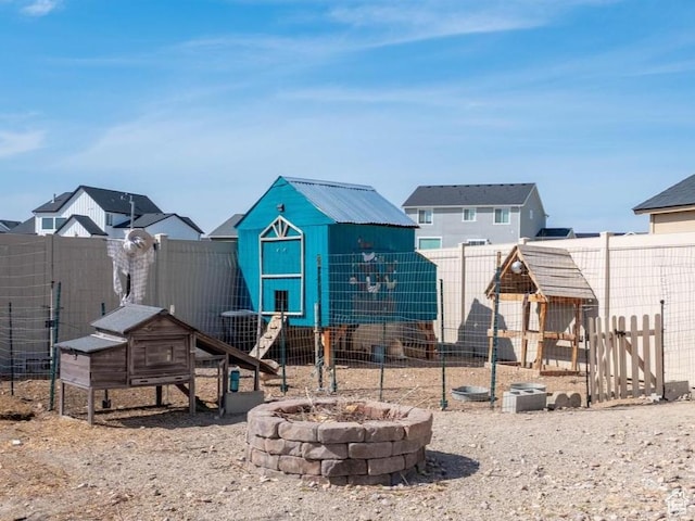 4687 E Jordan Way, Eagle Mountain, UT 84005 - view of play area with exterior structure, a fire pit, an outdoor structure, and a fenced backyard