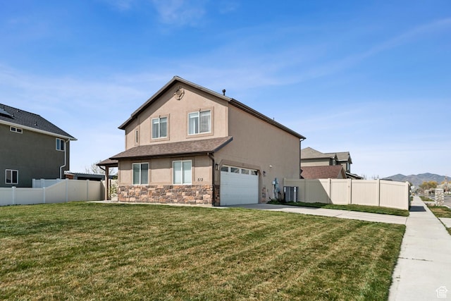 exterior space featuring stucco siding, fence, stone siding, an attached garage, and driveway