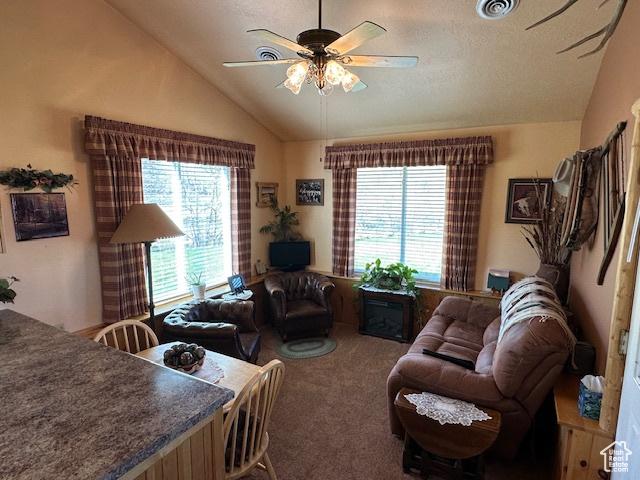 carpeted living area with visible vents, ceiling fan, and lofted ceiling