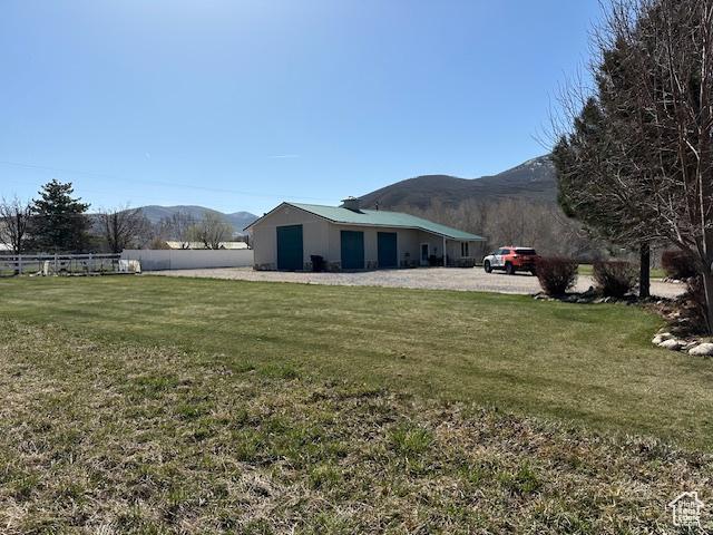 view of home's exterior featuring a yard, a mountain view, and fence