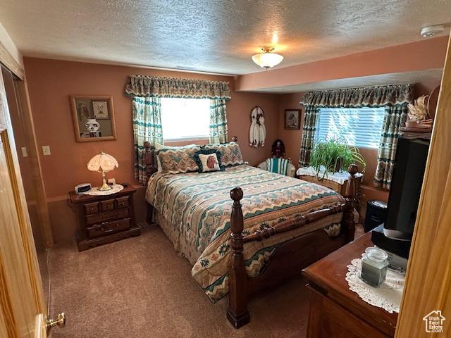 bedroom featuring light carpet and a textured ceiling