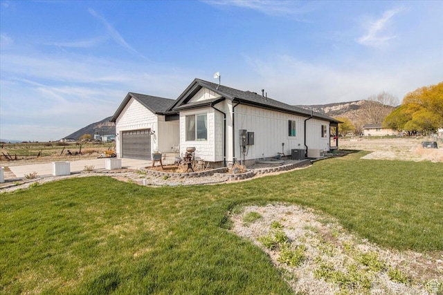 140 S 100 E, Wales, UT 84667 - view of side of home featuring central AC, a mountain view, a garage, a lawn, and board and batten siding