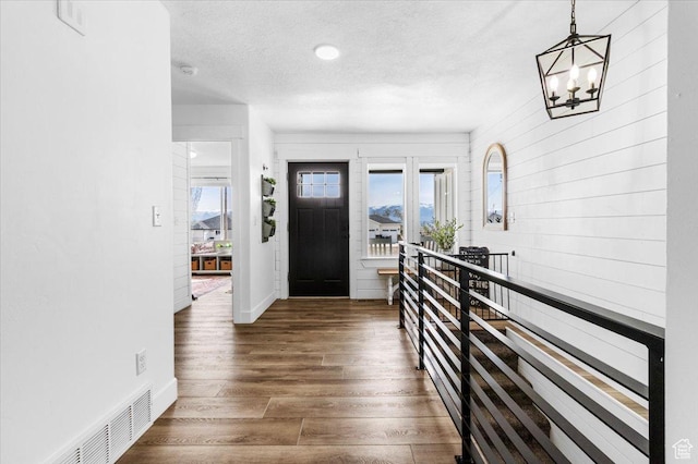140 S 100 E, Wales, UT 84667 - foyer entrance with baseboards, a chandelier, a textured ceiling, visible vents, and wood finished floors