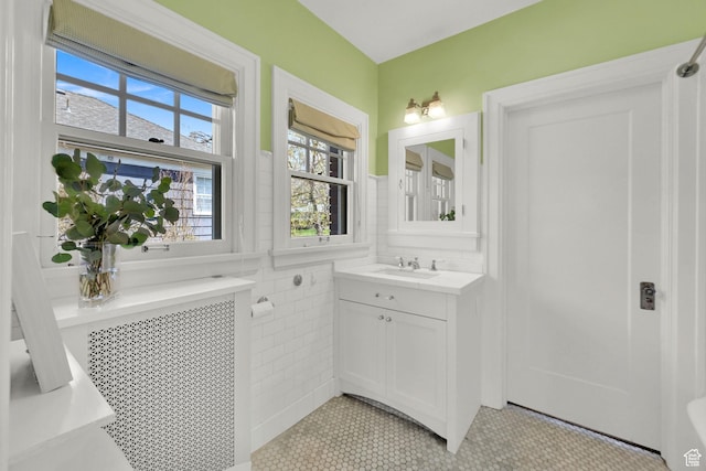 1401 E Sigsbee Ave, Salt Lake City, UT 84103 - bathroom with tile walls, a wainscoted wall, radiator heating unit, vanity, and tile patterned floors