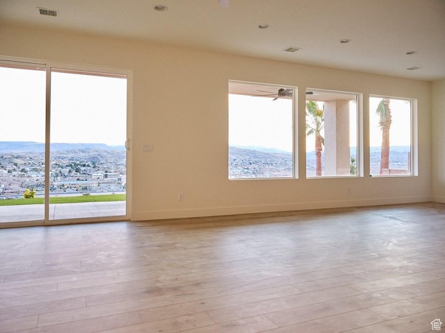 empty room with wood finished floors, baseboards, visible vents, and recessed lighting