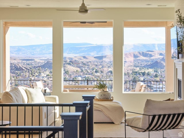 interior space with plenty of natural light, a mountain view, and ceiling fan