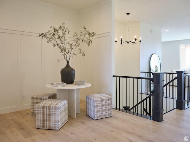 interior space featuring an upstairs landing, an inviting chandelier, and wood finished floors