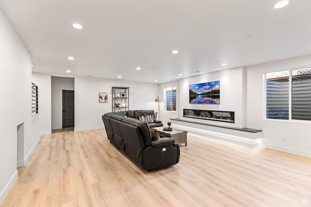 94 S 950 E, Hyde Park, UT 84318 - living room featuring a glass covered fireplace, light wood-type flooring, baseboards, recessed lighting, and a healthy amount of sunlight