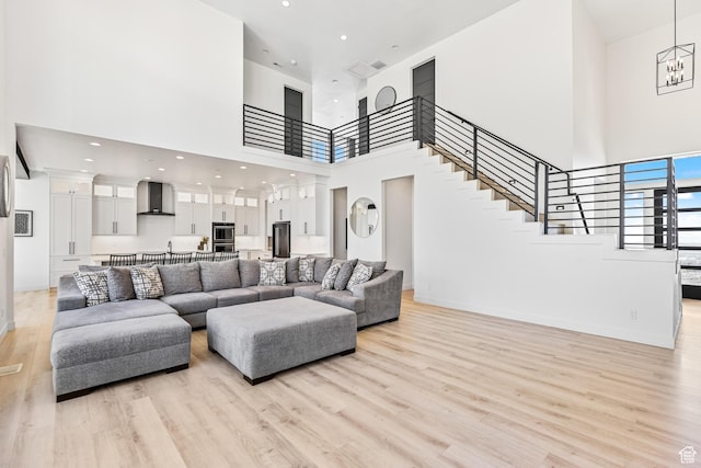 94 S 950 E, Hyde Park, UT 84318 - living room featuring light wood-style flooring, a high ceiling, baseboards, and stairway