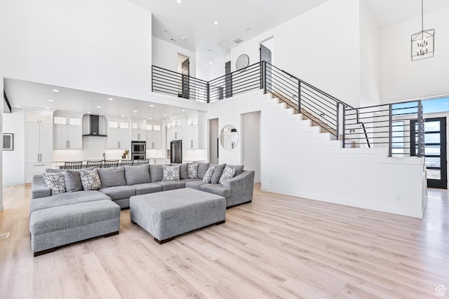 94 S 950 E, Hyde Park, UT 84318 - living area featuring an inviting chandelier, a high ceiling, stairs, light wood finished floors, and baseboards