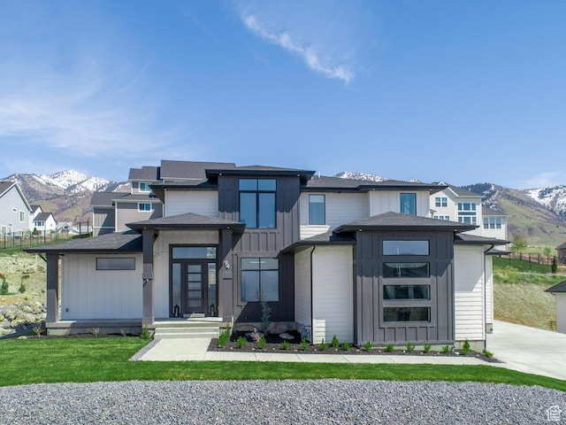 prairie-style house featuring board and batten siding, a mountain view, and a front yard