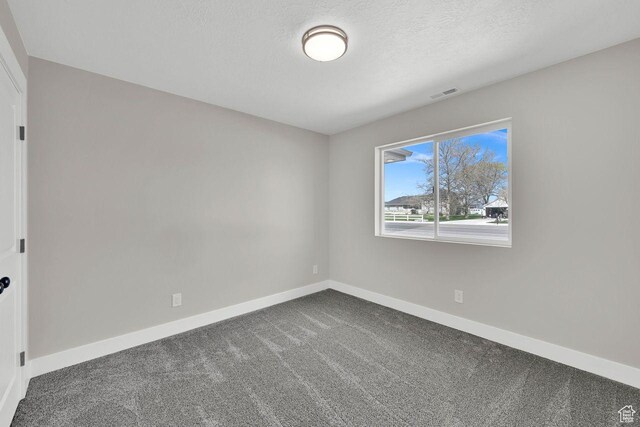 3005 W 3300 S, West Haven, UT 84401 - unfurnished room with visible vents, baseboards, dark carpet, and a textured ceiling