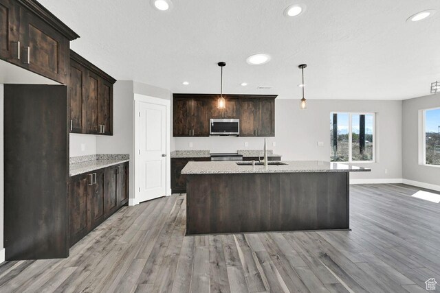 3005 W 3300 S, West Haven, UT 84401 - kitchen featuring baseboards, a sink, stainless steel microwave, recessed lighting, and light wood finished floors