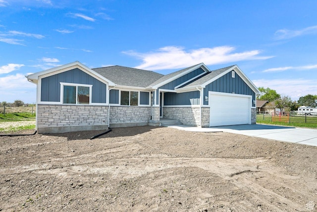 3005 W 3300 S, West Haven, UT 84401 - view of front of property featuring board and batten siding, an attached garage, stone siding, and driveway