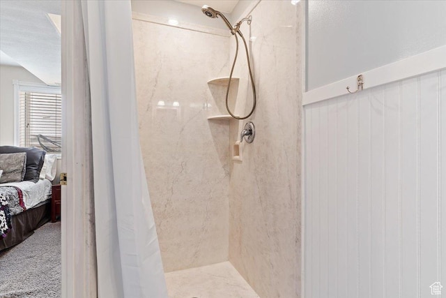 full bathroom with tiled shower and connected bathroom