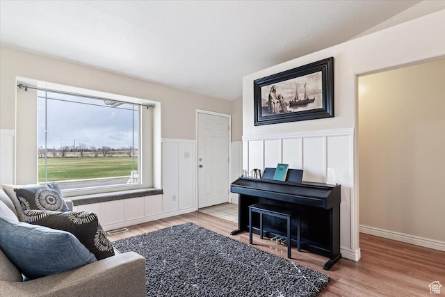 sitting room with visible vents, a wainscoted wall, and wood finished floors