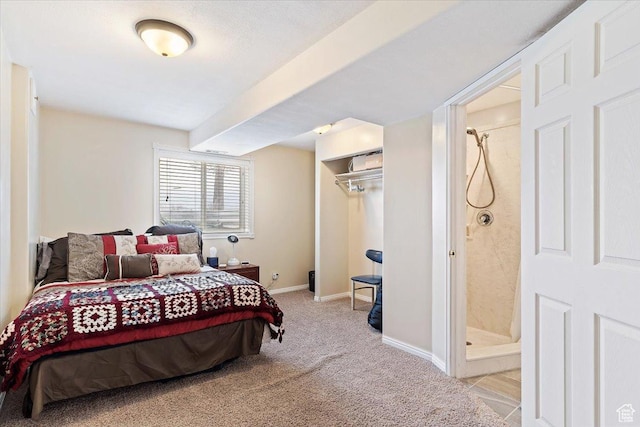 bedroom with a closet, ensuite bathroom, baseboards, and carpet floors