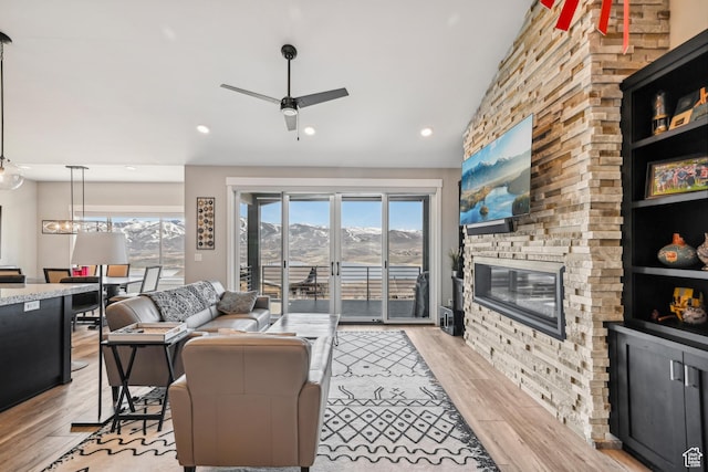 11285 N Shoreline Ct, Hideout, UT 84036 - living room with a stone fireplace, a ceiling fan, light wood-style floors, recessed lighting, and vaulted ceiling