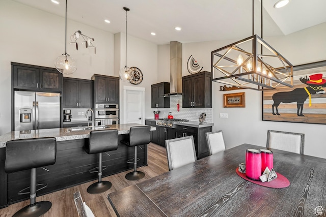 11285 N Shoreline Ct, Hideout, UT 84036 - kitchen with tasteful backsplash, a sink, wall chimney range hood, wood finished floors, and stainless steel appliances