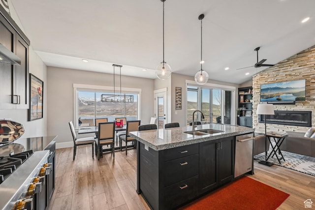 11285 N Shoreline Ct, Hideout, UT 84036 - kitchen featuring dark cabinets, open floor plan, a ceiling fan, light wood-style floors, and a sink