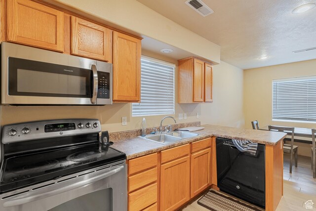 2930 E 450 N Unit F6, St George, UT 84790 - kitchen featuring a peninsula, a sink, visible vents, light countertops, and appliances with stainless steel finishes