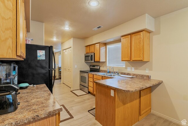 2930 E 450 N Unit F6, St George, UT 84790 - kitchen featuring light wood finished floors, stainless steel appliances, visible vents, a sink, and a peninsula