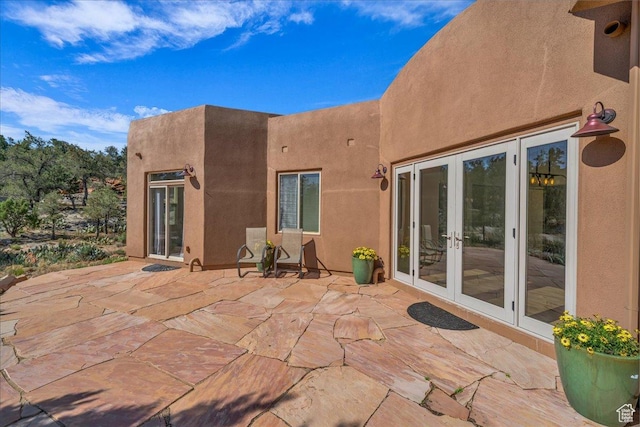 back of house featuring a patio, french doors, and stucco siding