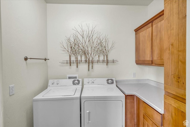 laundry area with independent washer and dryer and cabinet space