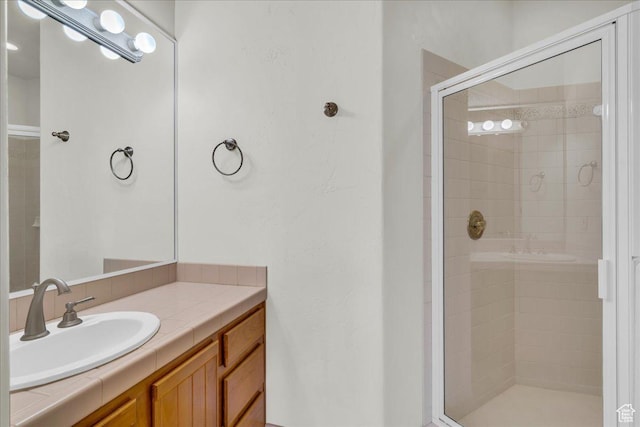 bathroom featuring a shower stall and vanity