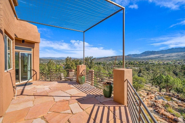view of patio with a balcony and a mountain view
