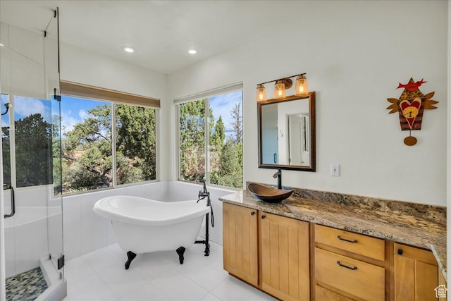 full bathroom featuring a freestanding tub, vanity, recessed lighting, tile patterned floors, and a shower stall