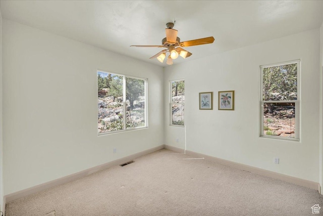 spare room featuring visible vents, ceiling fan, baseboards, and carpet
