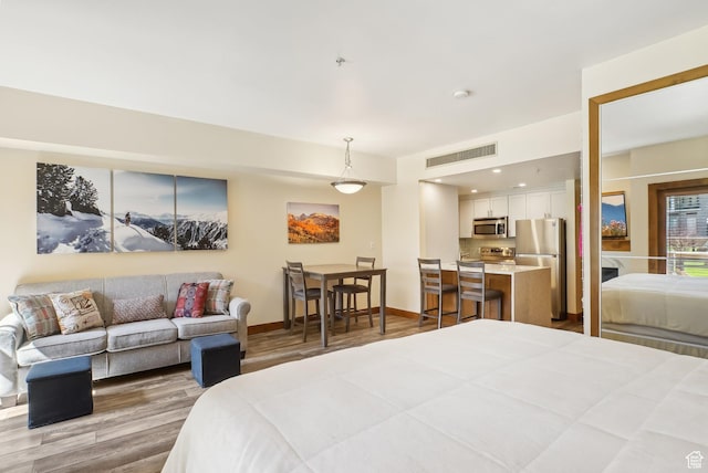 3720 N Sundial Ct Unit Cg02, Park City, UT 84098 - bedroom with visible vents, baseboards, freestanding refrigerator, and wood finished floors