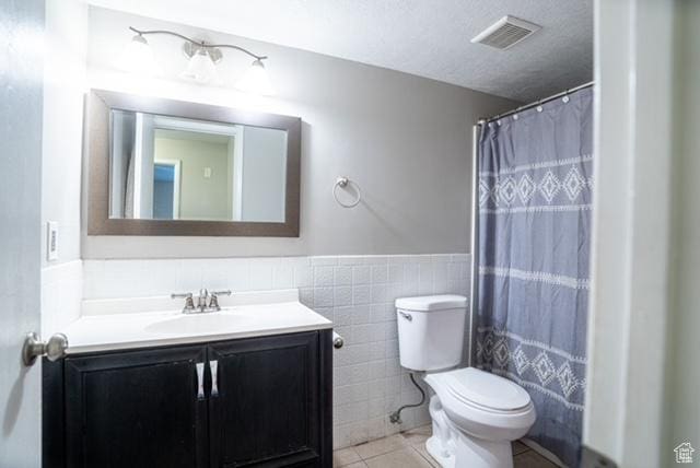 3198 S 300 E Unit 10, South Salt Lake, UT 84115 - bathroom with vanity, tile patterned flooring, visible vents, toilet, and tile walls