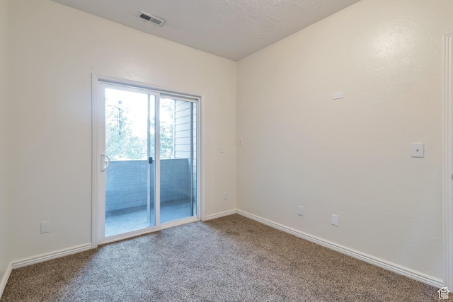 spare room featuring carpet, visible vents, and baseboards
