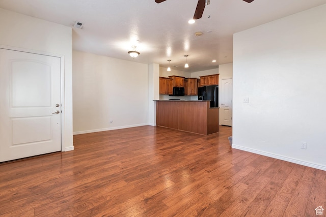 unfurnished living room featuring wood finished floors, ceiling fan, baseboards, and visible vents