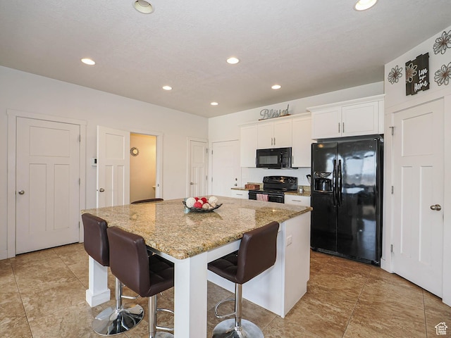 8092 W Rock Creek Cove Ln, Eagle Mountain, UT 84005 - kitchen featuring light stone countertops, white cabinets, recessed lighting, black appliances, and a kitchen island