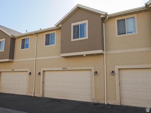 8092 W Rock Creek Cove Ln, Eagle Mountain, UT 84005 - rear view of house featuring a garage and stucco siding