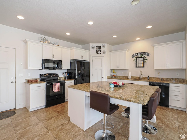 8092 W Rock Creek Cove Ln, Eagle Mountain, UT 84005 - kitchen with white cabinetry, a kitchen island, black appliances, a kitchen bar, and a sink