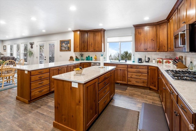 1510 S Mahogany Dr, Garden City, UT 84028 - kitchen featuring a peninsula, dark wood-style floors, brown cabinets, decorative backsplash, and appliances with stainless steel finishes