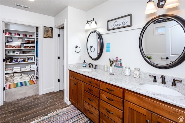 1510 S Mahogany Dr, Garden City, UT 84028 - bathroom with double vanity, visible vents, a sink, and wood finish floors
