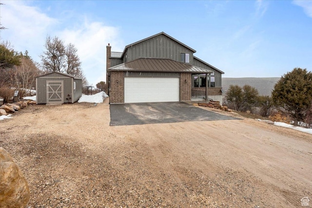 1510 S Mahogany Dr, Garden City, UT 84028 - view of front facade featuring a standing seam roof, metal roof, a garage, an outdoor structure, and driveway