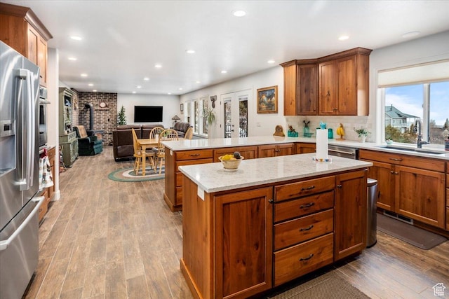 1510 S Mahogany Dr, Garden City, UT 84028 - kitchen featuring a wood stove, wood finished floors, a sink, stainless steel fridge, and open floor plan