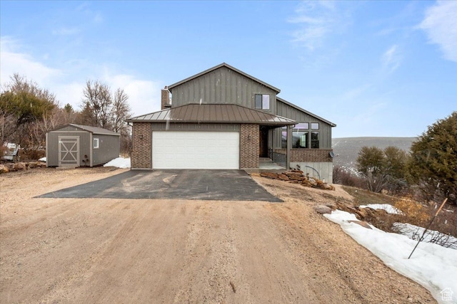 1510 S Mahogany Dr, Garden City, UT 84028 - view of front facade featuring a standing seam roof, metal roof, brick siding, an attached garage, and driveway