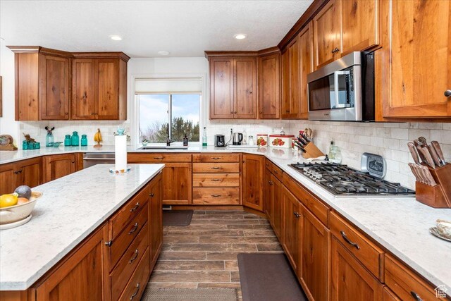 1510 S Mahogany Dr, Garden City, UT 84028 - kitchen featuring a sink, dark wood-style floors, brown cabinets, stainless steel appliances, and decorative backsplash