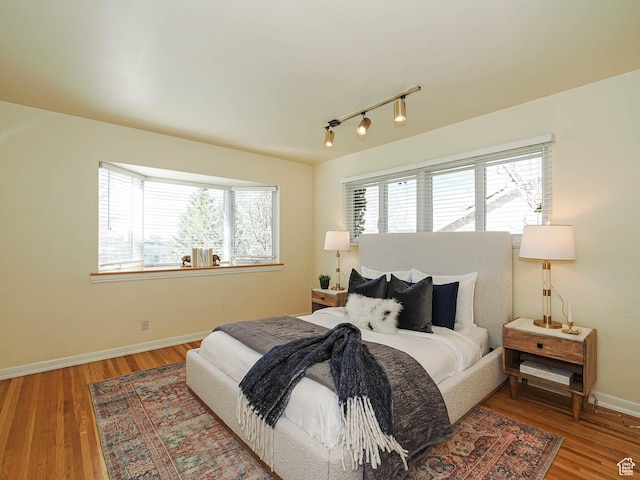 2463 E Michigan Ave S, Salt Lake City, UT 84108 - bedroom featuring rail lighting, baseboards, and wood finished floors