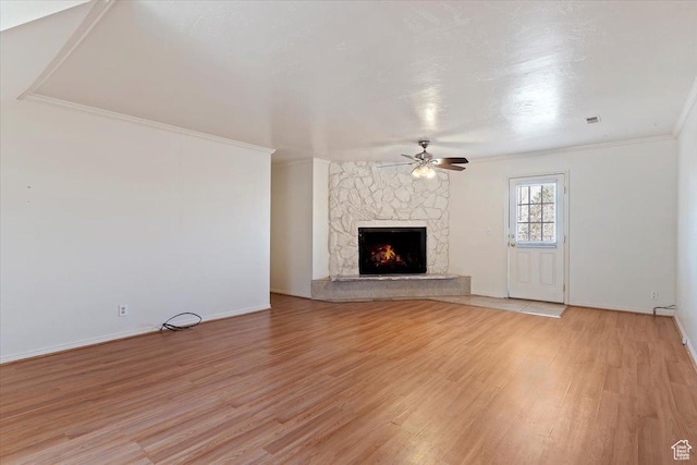 1202 E Mutton Hollow Rd, Kaysville, UT 84037 - unfurnished living room with baseboards, a stone fireplace, light wood-type flooring, a ceiling fan, and crown molding