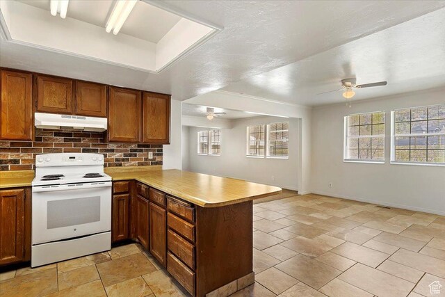 1202 E Mutton Hollow Rd, Kaysville, UT 84037 - kitchen with white electric range, tasteful backsplash, a peninsula, a ceiling fan, and under cabinet range hood