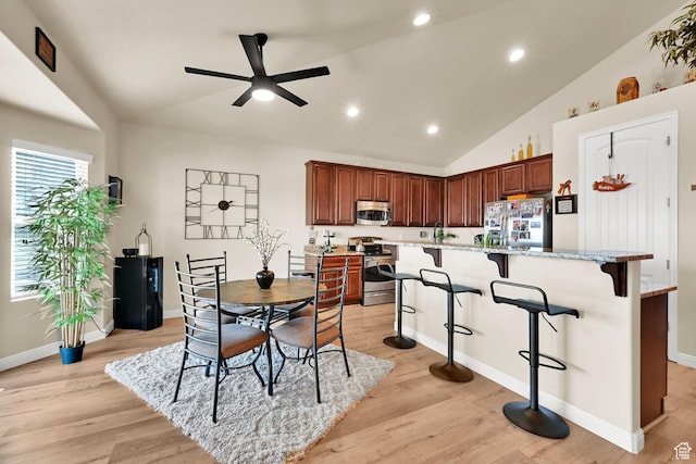 dining space featuring baseboards, ceiling fan, recessed lighting, light wood finished floors, and vaulted ceiling